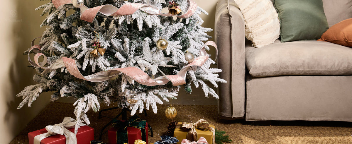 Blush pink velvet ribbon with metallic reverse spiraling around a flocked Christmas tree
