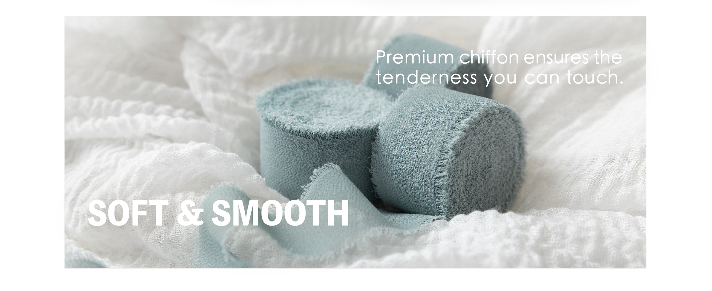 Dusty blue chiffon ribbon rolls with soft woven texture and frayed edges resting on white fabric.