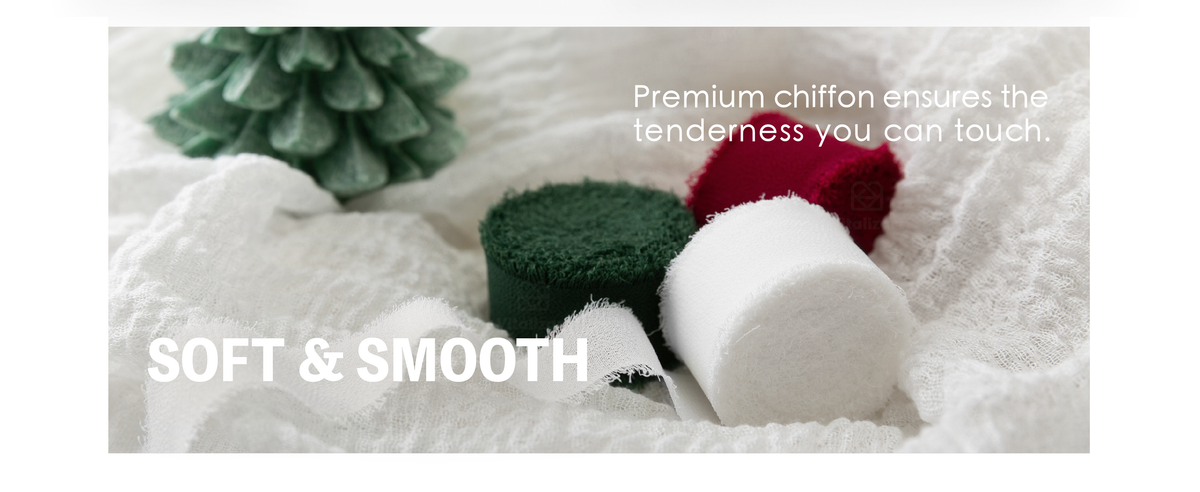 Red, white and dark green chiffon ribbon rolls with frayed edges on soft white fabric