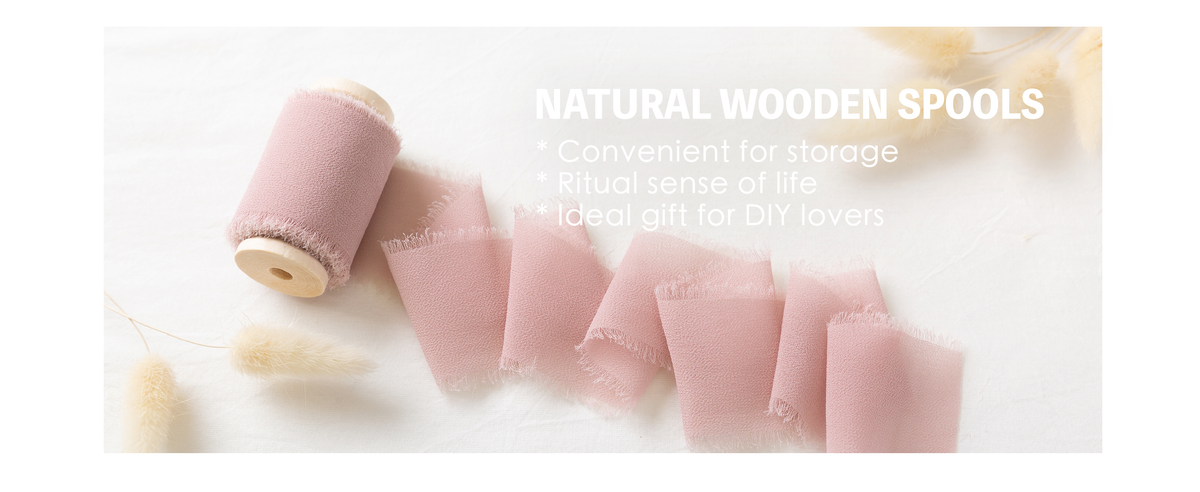 Dusty pink chiffon ribbon with frayed edges unfurling from a natural wooden spool on white fabric.