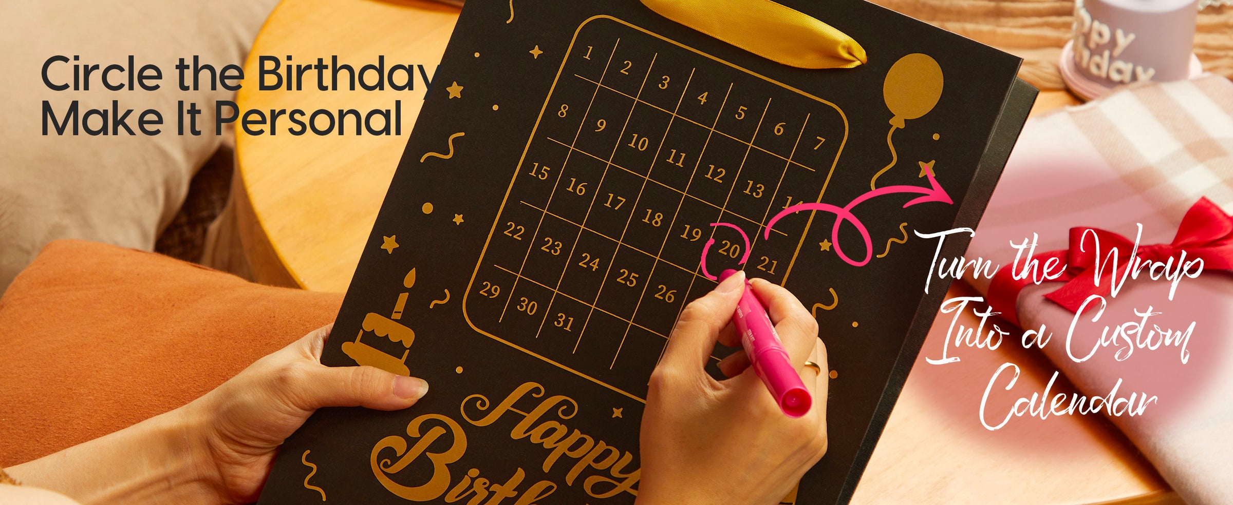 Person circles a date on a black birthday gift bag with gold calendar design and ribbon handle