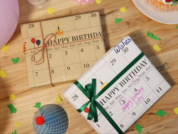 Birthday gifts wrapped in calendar-patterned paper and satin ribbon