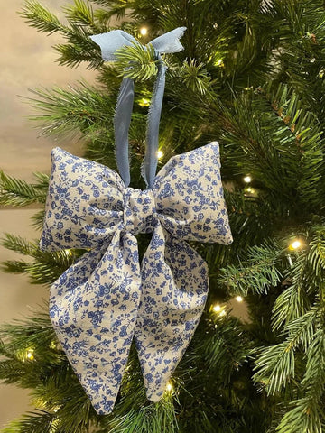 Blue floral fabric bow hanging on a Christmas tree