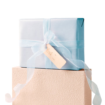 Blue gift wrapped with organza ribbon and an ivory gift tag