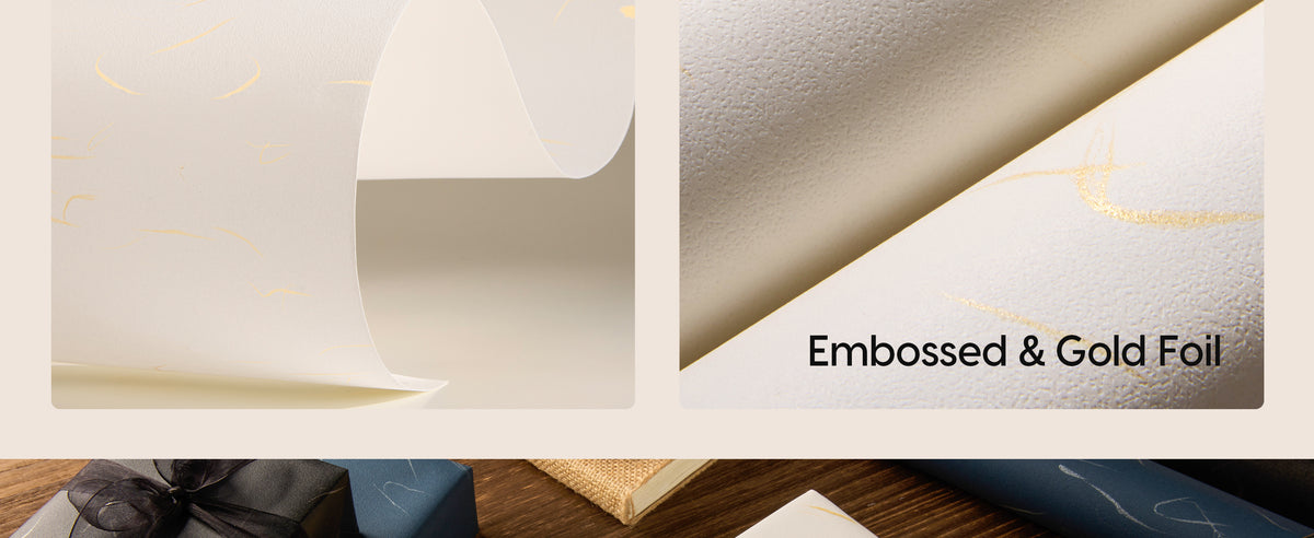 Close-up of white wrapping paper with pebbled embossing and reflective gold foil lines.