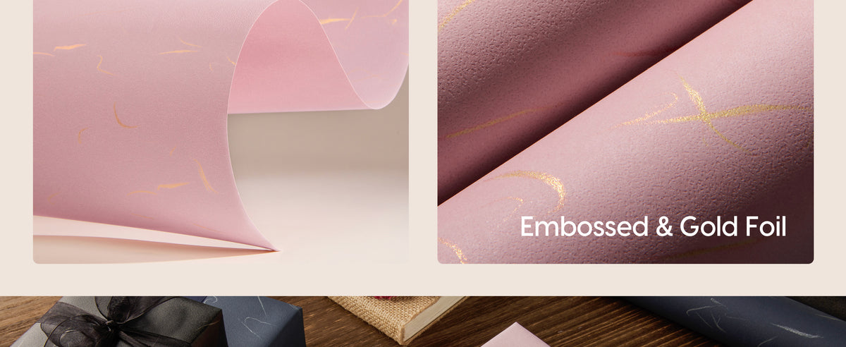 Close-up of pink wrapping paper with pebbled embossing and reflective gold foil lines.