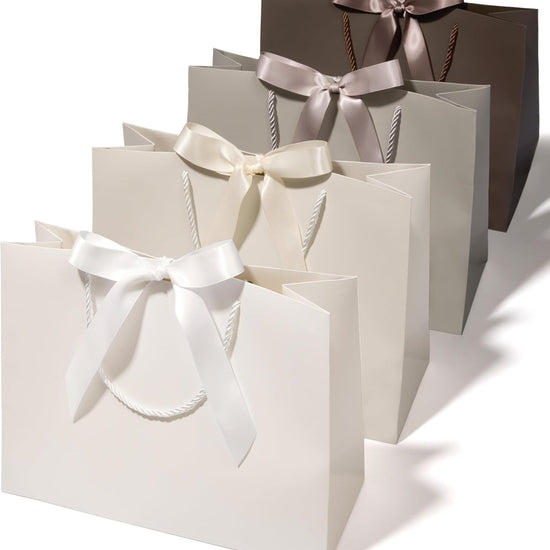 Set of four large cream and champagne paper gift bags with ribbon handles