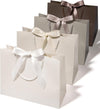 Set of four large cream and champagne paper gift bags with ribbon handles
