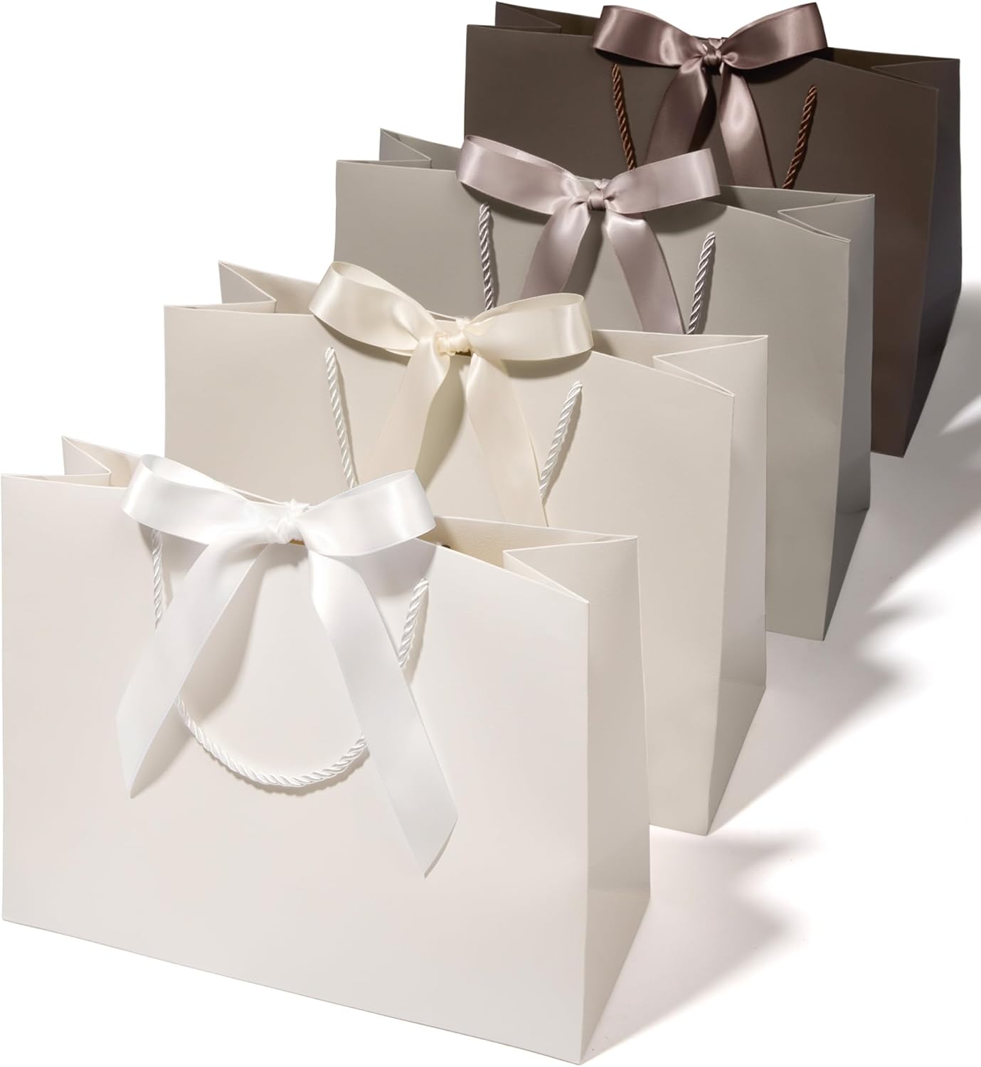 Set of four large cream and champagne paper gift bags with ribbon handles