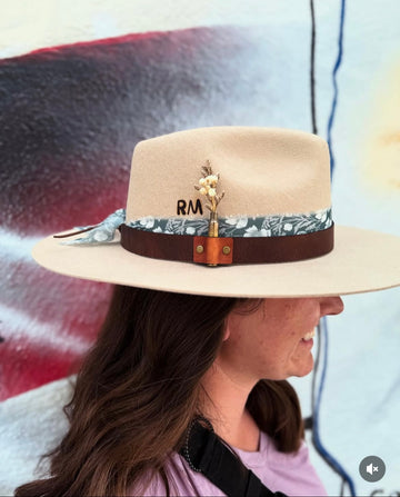Cream felt hat decorated with floral and dark brown ribbons