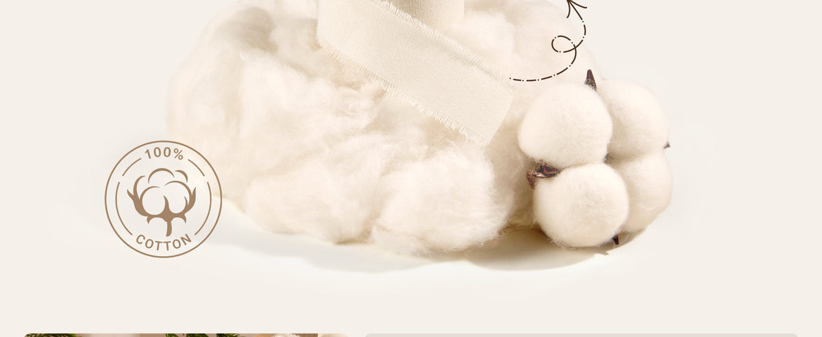 Ivory fringed cotton ribbon draped over raw cotton fiber beside a natural cotton boll.