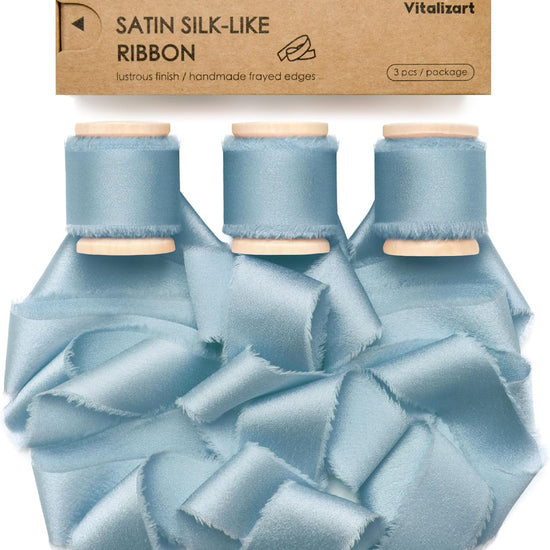 Dusty blue silk satin ribbon on a wooden spool