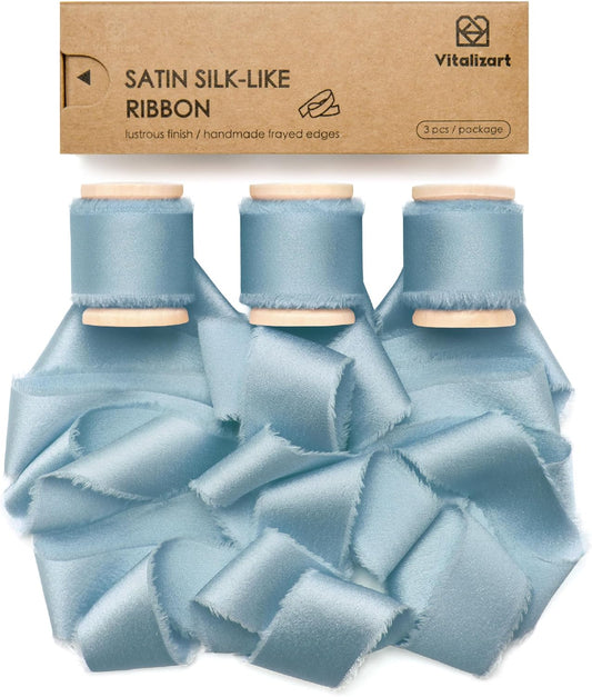 Dusty blue silk satin ribbon on a wooden spool