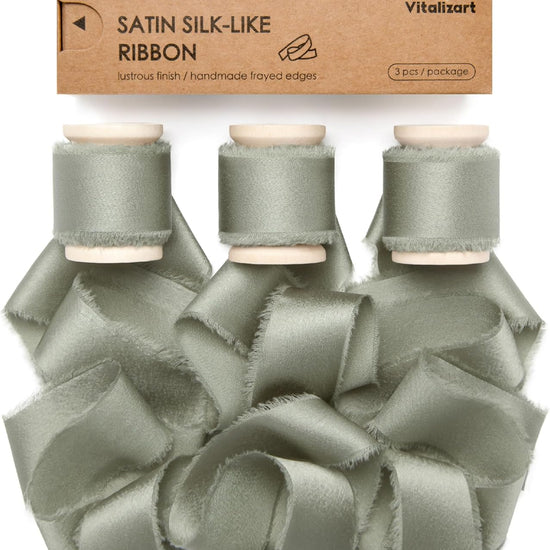 Dusty green silk satin ribbon on a wooden spool