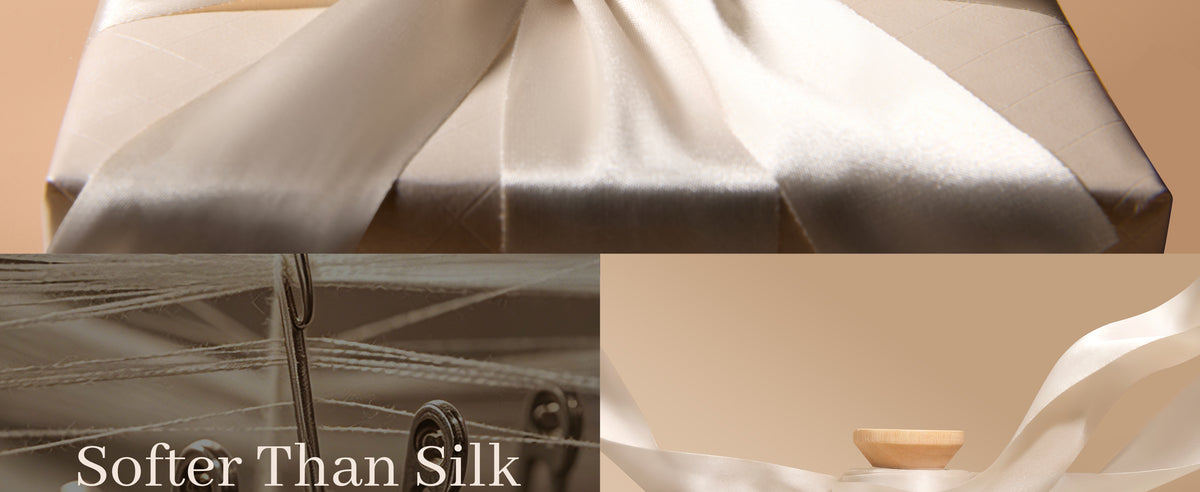 Close-up of smooth ivory satin ribbon with soft sheen beside thread and sewing equipment.