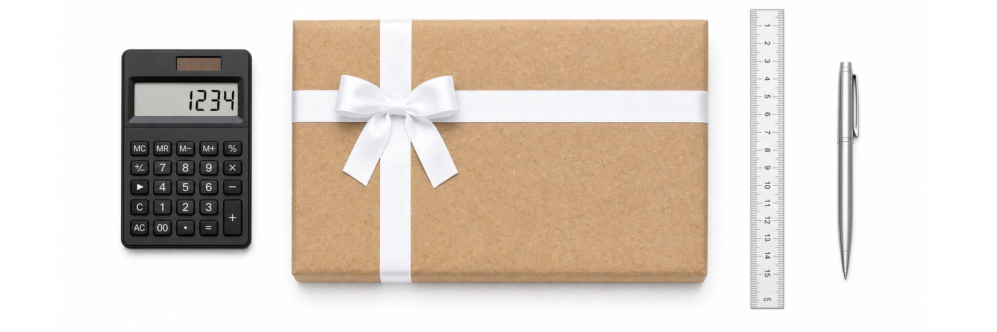 Gift box tied with white ribbon beside a calculator, ruler and pen