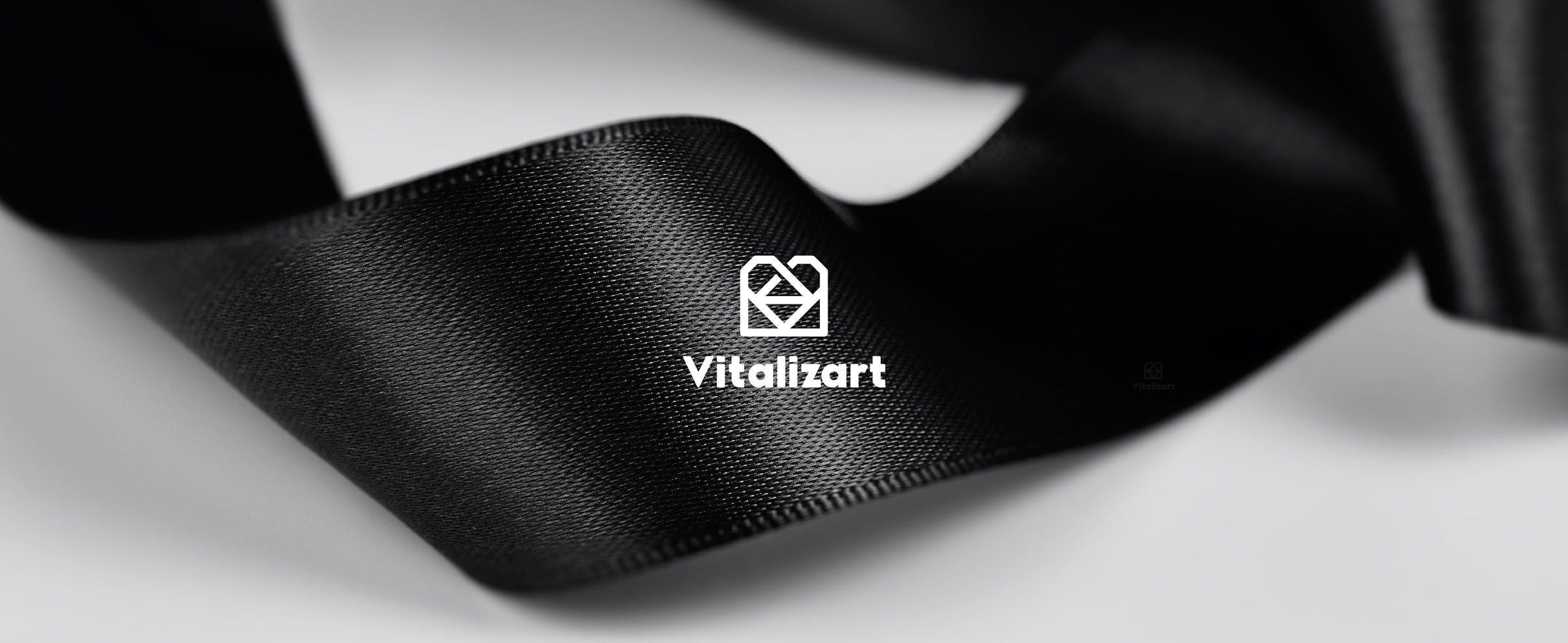 Glossy black satin ribbon in soft folds, showing its fine woven texture and finished edges.
