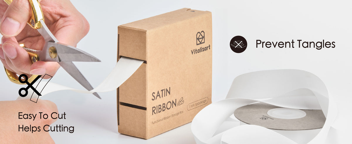 Two brown cardboard satin ribbon boxes stacked on gray fabric in diagonal sunlight.