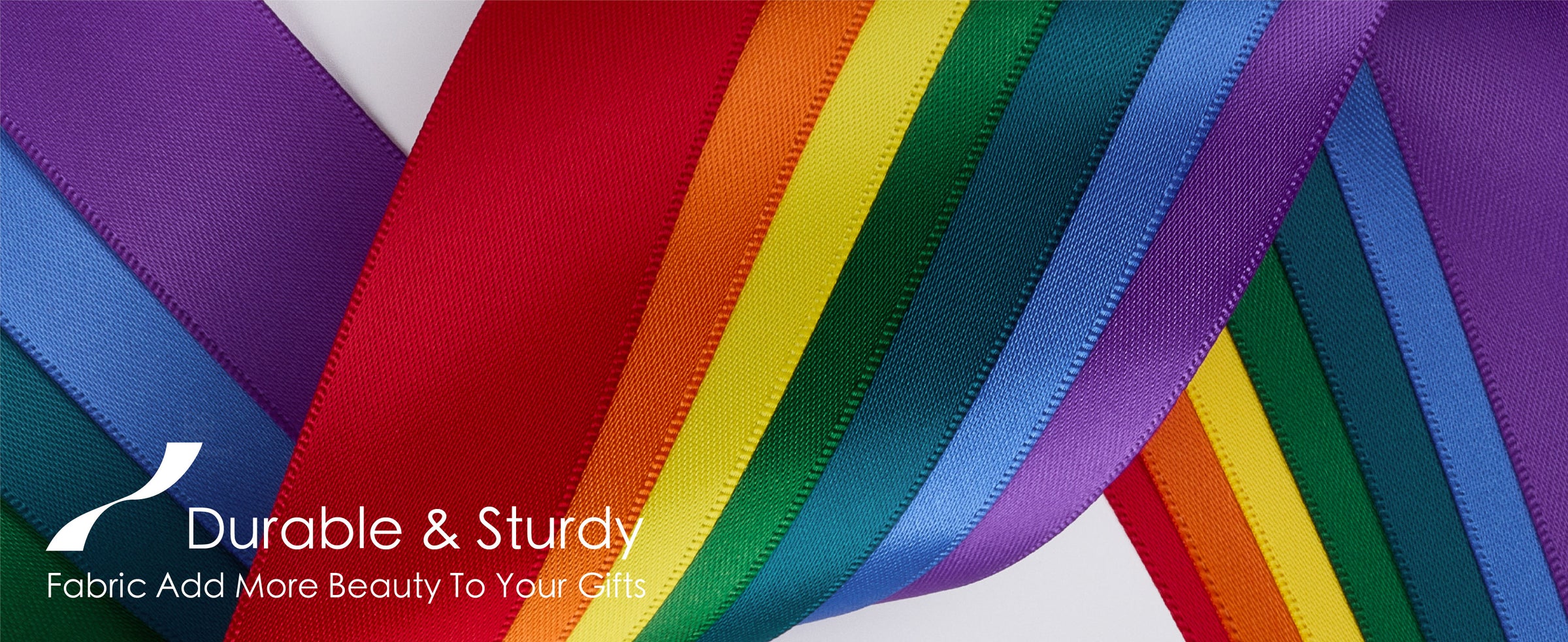 Red, orange, yellow, green, teal, blue, and purple satin ribbons crossing on white
