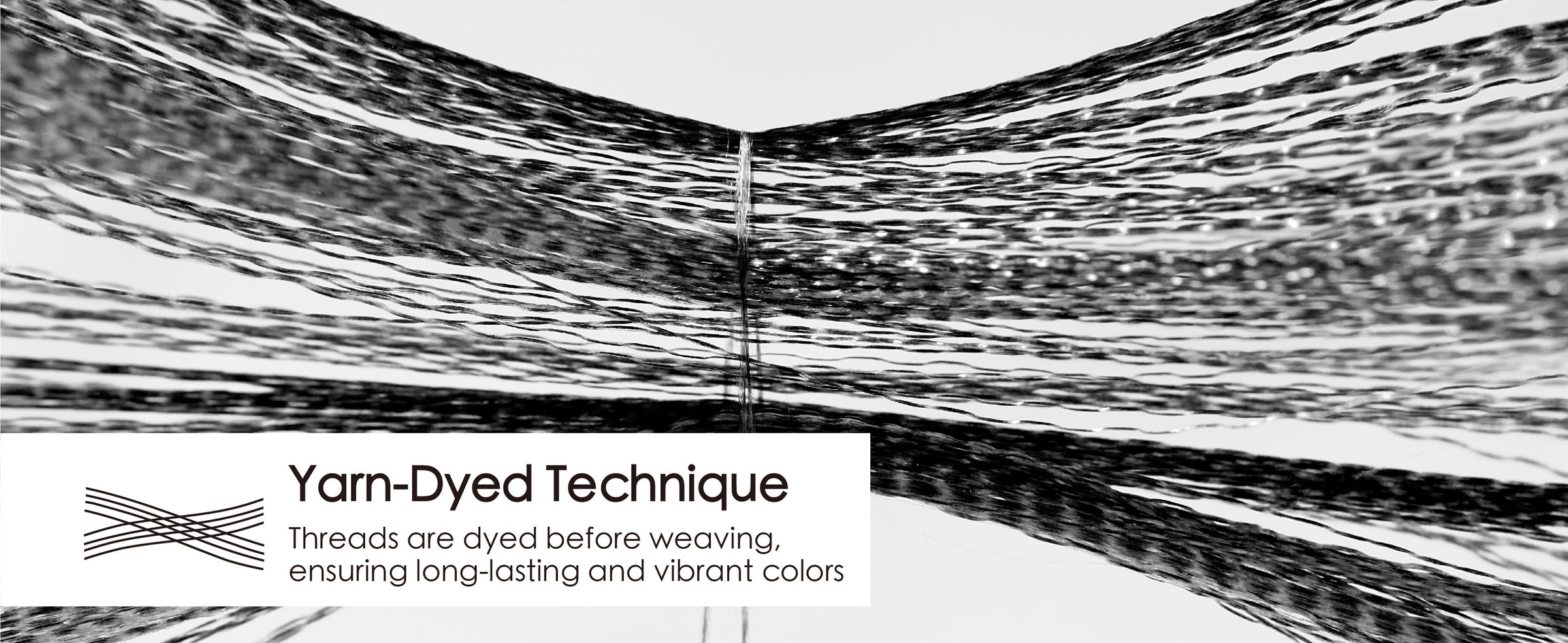 Magnified black ribbon fibers separate into fine strands to illustrate the yarn-dyed weaving technique.
