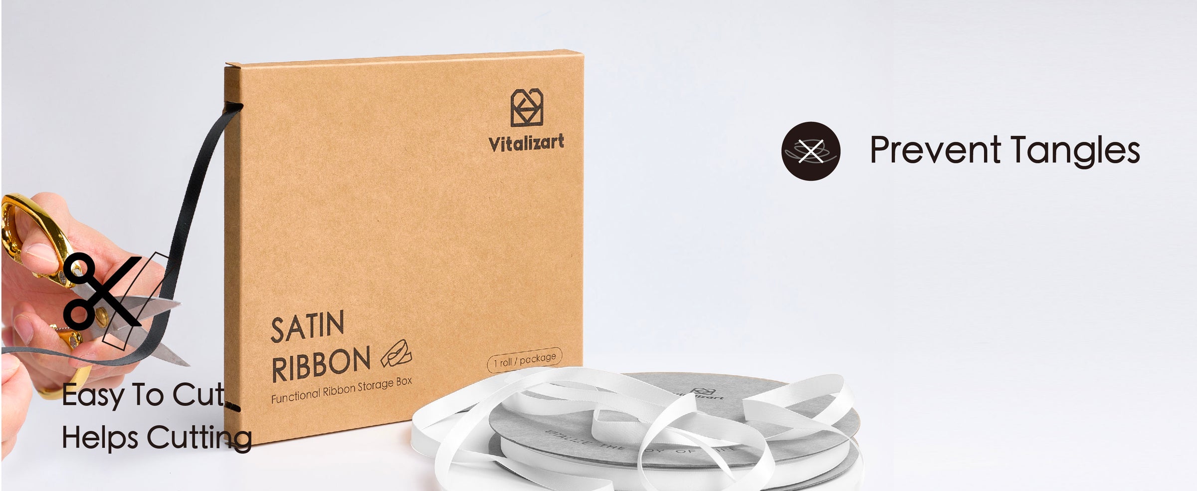 Black satin ribbon dispenses from a kraft storage box while being cut with scissors beside ribbon spools.