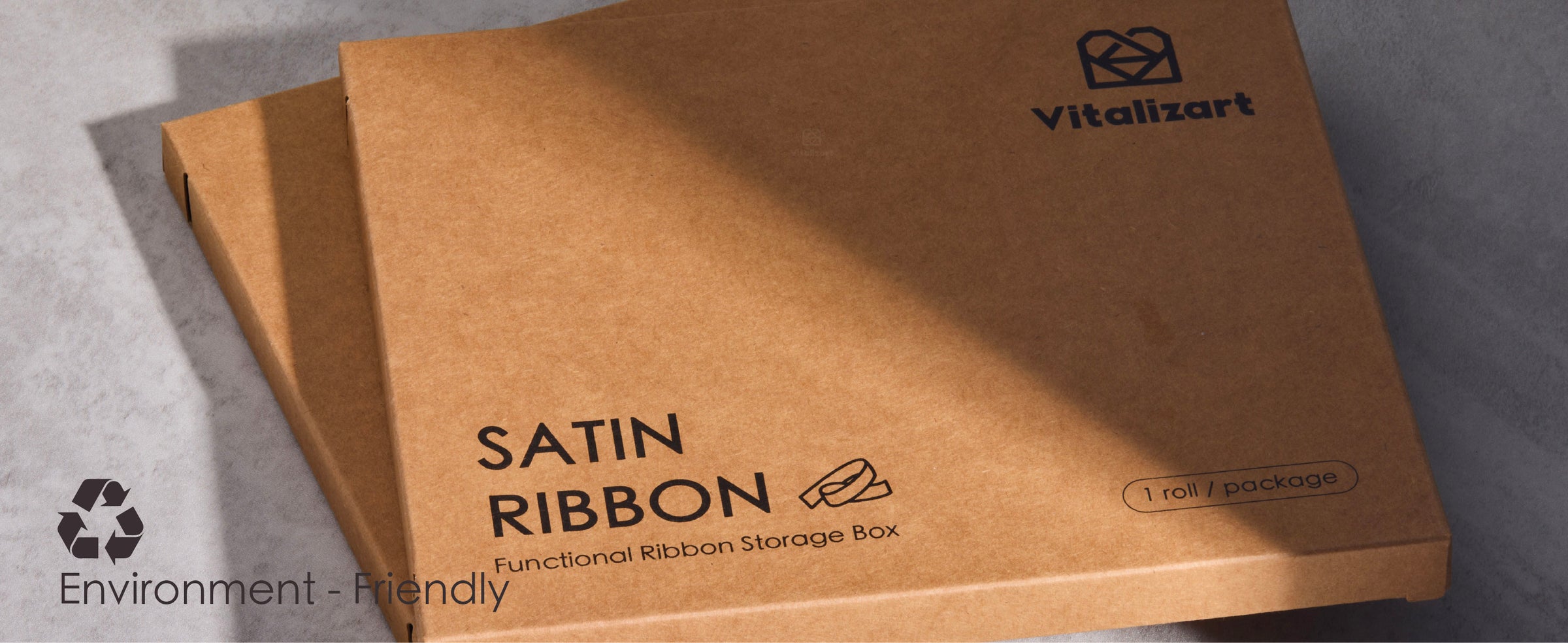 Blue satin ribbon dispenses from a kraft storage box as a hand cuts it with scissors.