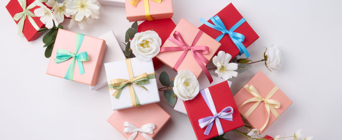 Wrapped gifts decorated with layered bows made from the pastel double-faced satin ribbon set