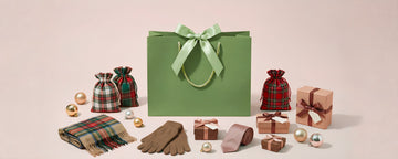 Green gift bag and ribbon-wrapped gifts with holiday accessories