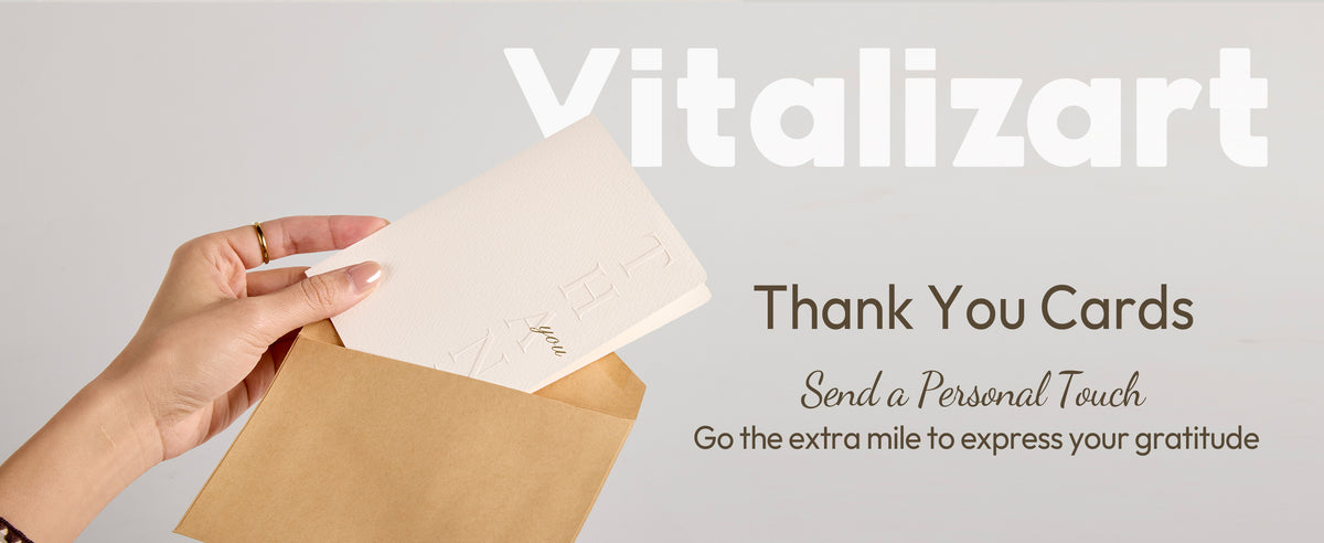 White embossed thank-you cards and envelopes arranged on a neutral tabletop with stationery accessories