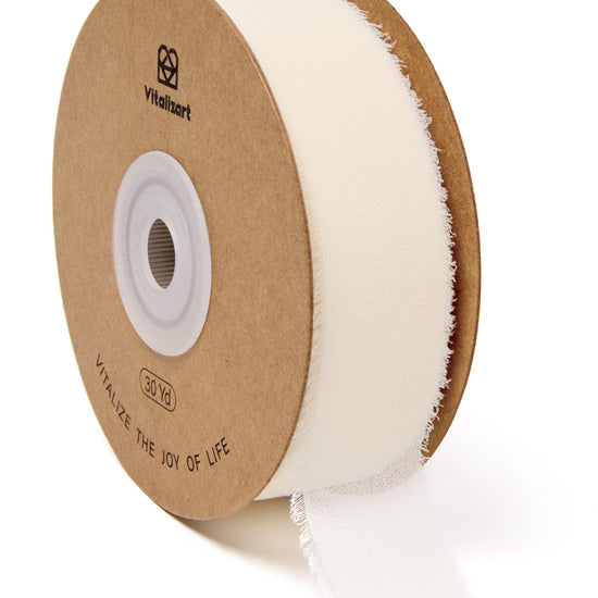 Ivory white fringe chiffon ribbon roll on a white background