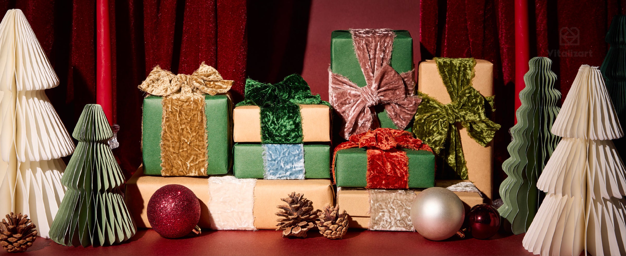 Christmas gifts wrapped with layered frayed-edge velvet ribbon among paper trees and ornaments