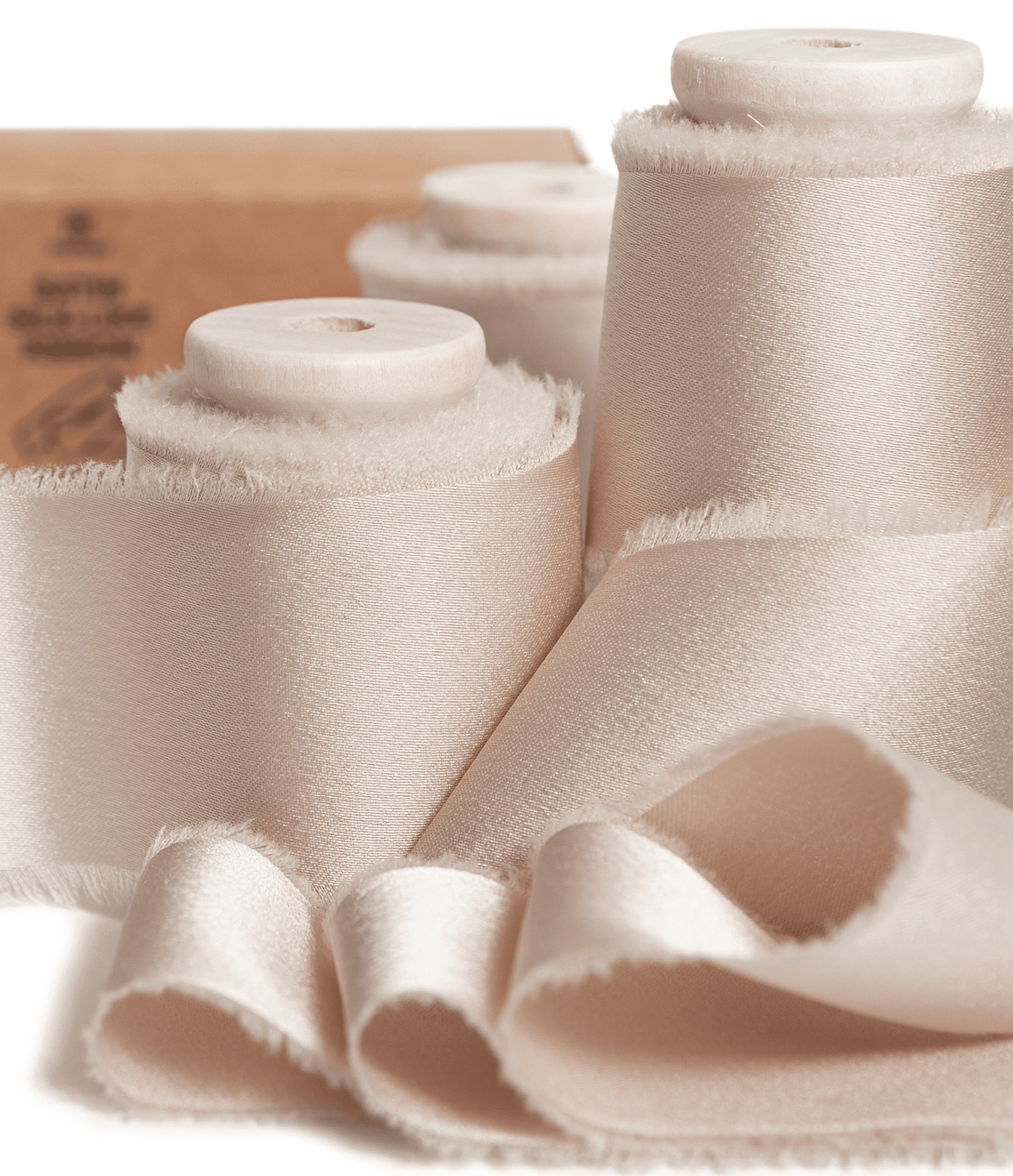 Light nude silk satin ribbon wound on a wooden spool