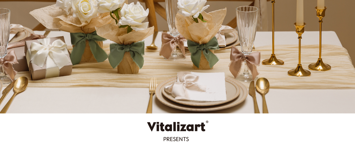 Elegant table setting with ribbon-tied glasses, wrapped rose centerpieces, candles, and a bow-topped gift