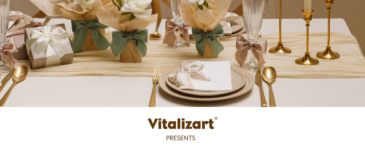 Candlelit formal table with ribbon-tied white roses, stemware, gold flatware, and a wrapped gift