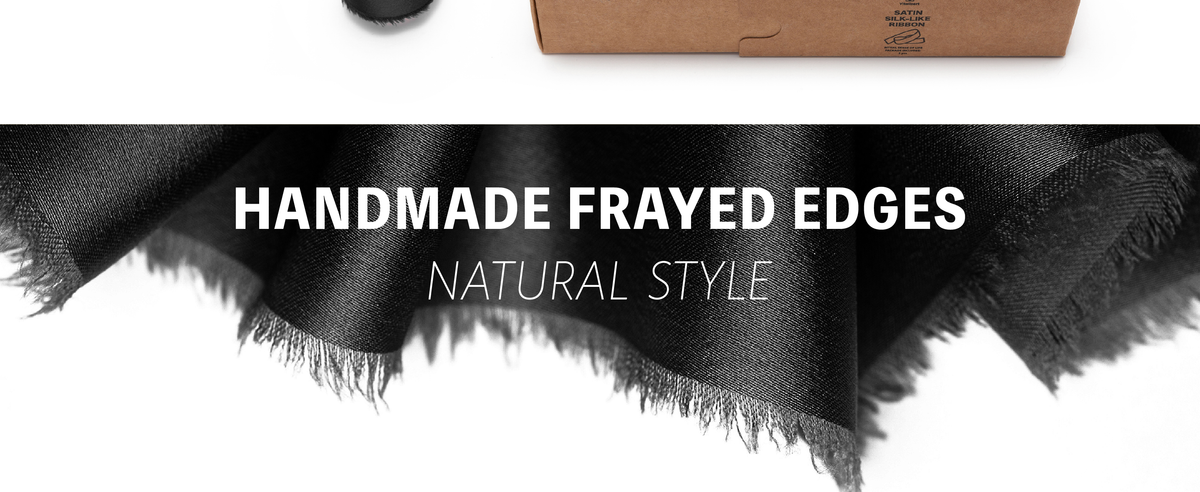 Close-up of black satin-like ribbon with a subtly lustrous surface and soft frayed edges