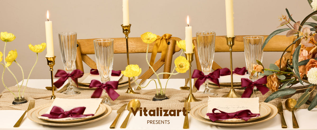 Burgundy ribbon bows accent glasses, napkins, and cards on a candlelit formal dining table