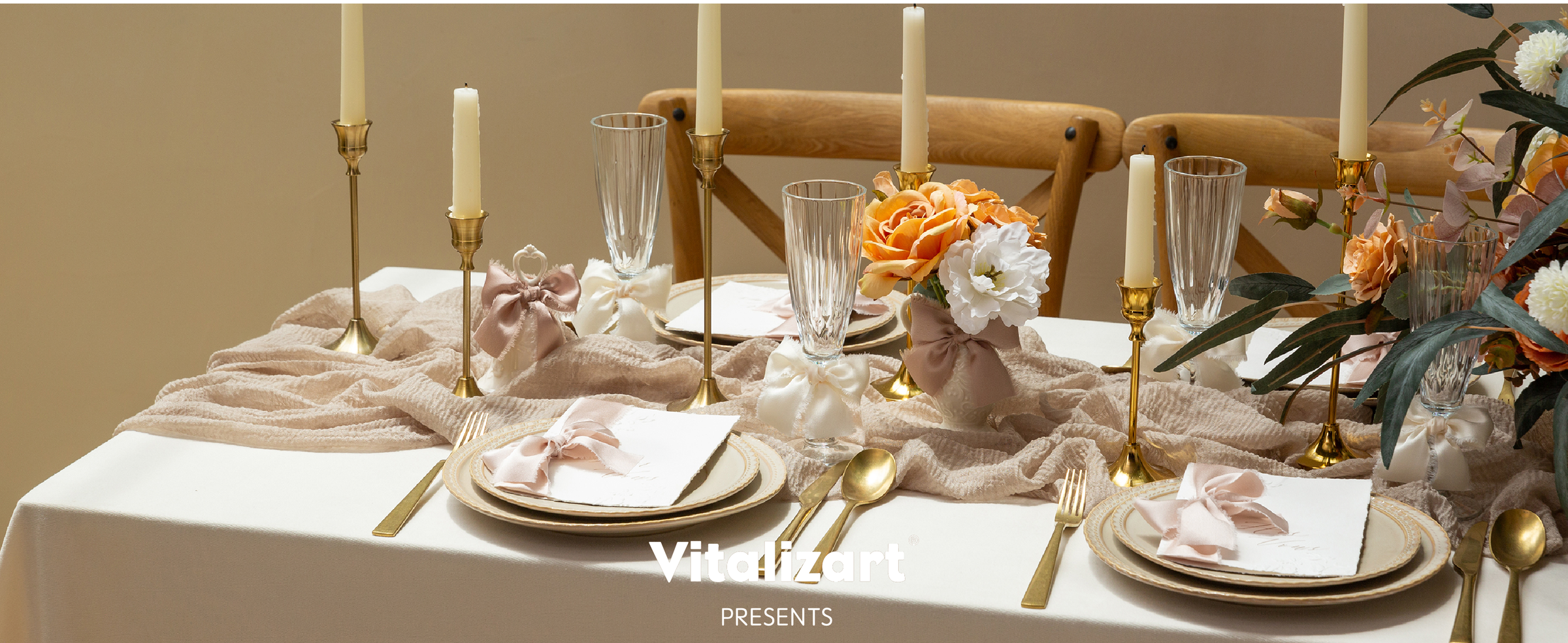 Pink, gold, and peach satin bows decorate a table with yellow flowers and pink candles