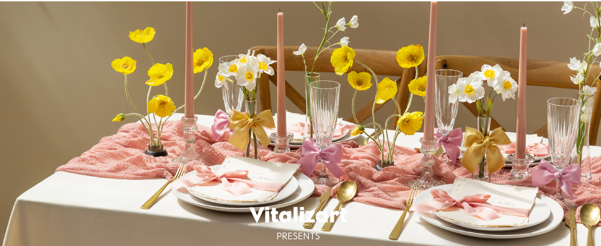 Ivory and blush satin ribbon bows accent an elegant candlelit table with flowers and gold place settings.