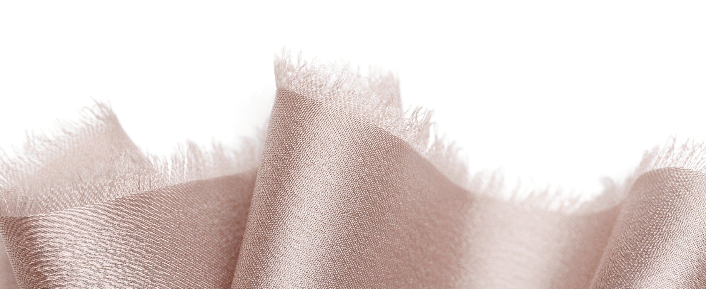 Nude-pink satin ribbon in overlapping folds, highlighting its fine weave, soft sheen, and frayed edges.