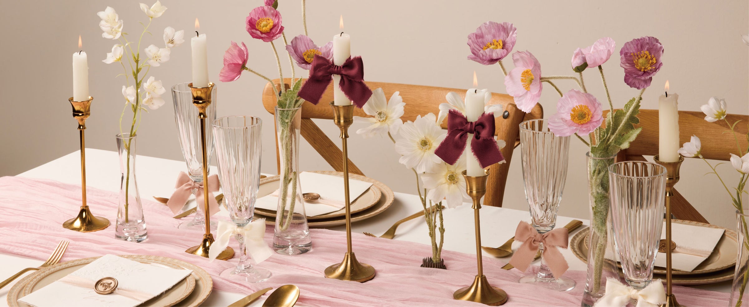 Kraft gift boxes tied with burgundy and pale blush frayed satin ribbon beside 30-yard spools