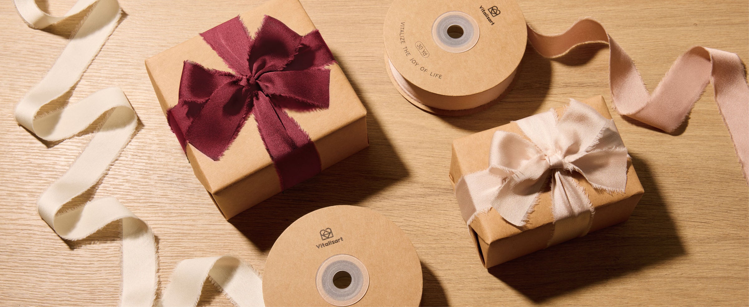 Burgundy satin ribbon bows decorate candles on a floral table set with gold accents