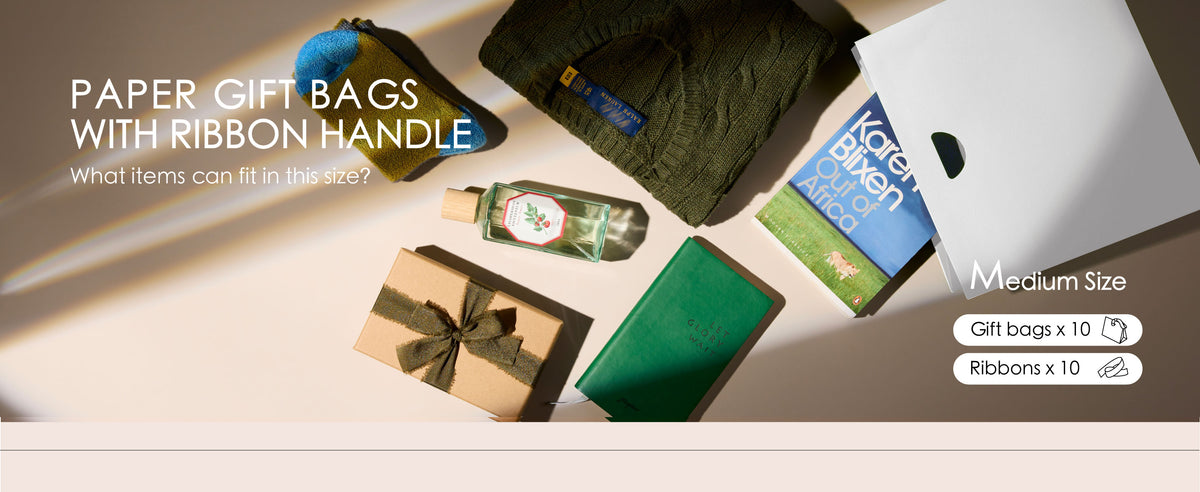 Assorted-color medium paper gift bags with ribbon handles styled beside gifts, cards, and small accessories