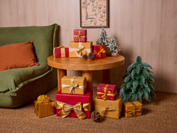 Luxury Christmas gift wrapping ideas featuring velvet ribbons on red and gold gift boxes.