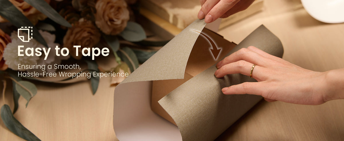 Hands folding brown-beige textured wrapping paper over a rectangular gift box