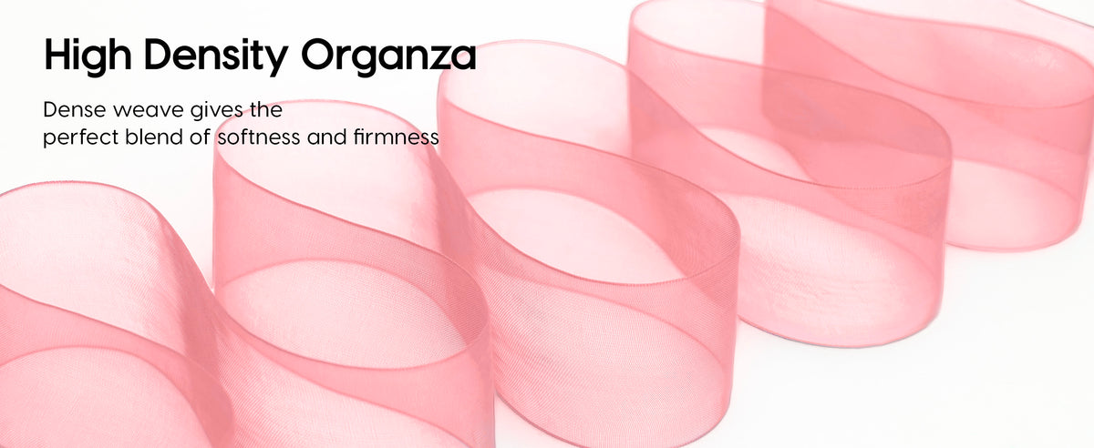 Bright pink organza ribbon in broad loops, showing its sheer, finely woven texture and finished edges.