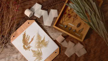 Frayed ribbons and dried botanicals representing plant-based dyes