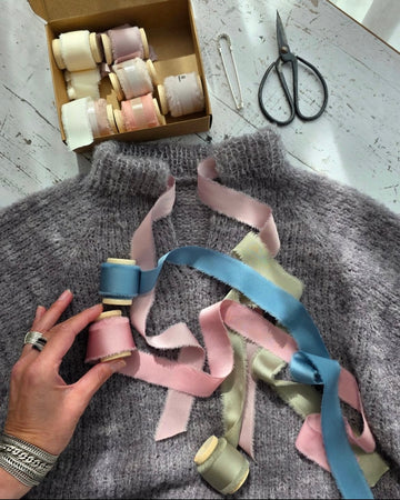 Pastel frayed ribbons arranged on gray knit fabric
