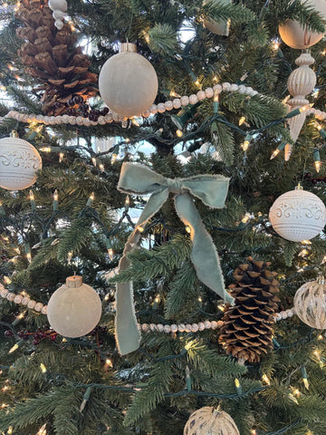 Sage frayed ribbon bow decorating a Christmas tree