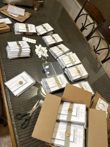Wedding invitation suites tied with sage ribbon and sealed with gold wax