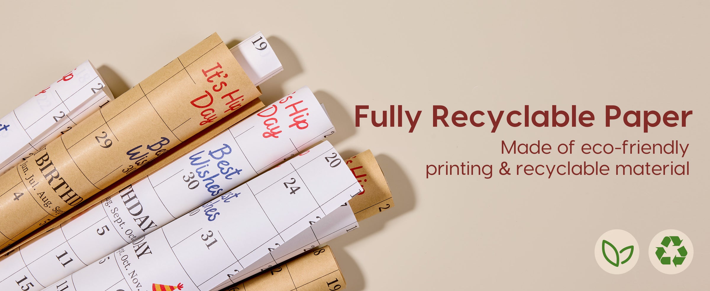 Layered rolls of brown and white calendar birthday wrapping paper with recycling symbols